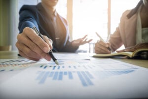 Dois homens sentados, analisando gráficos financeiros
